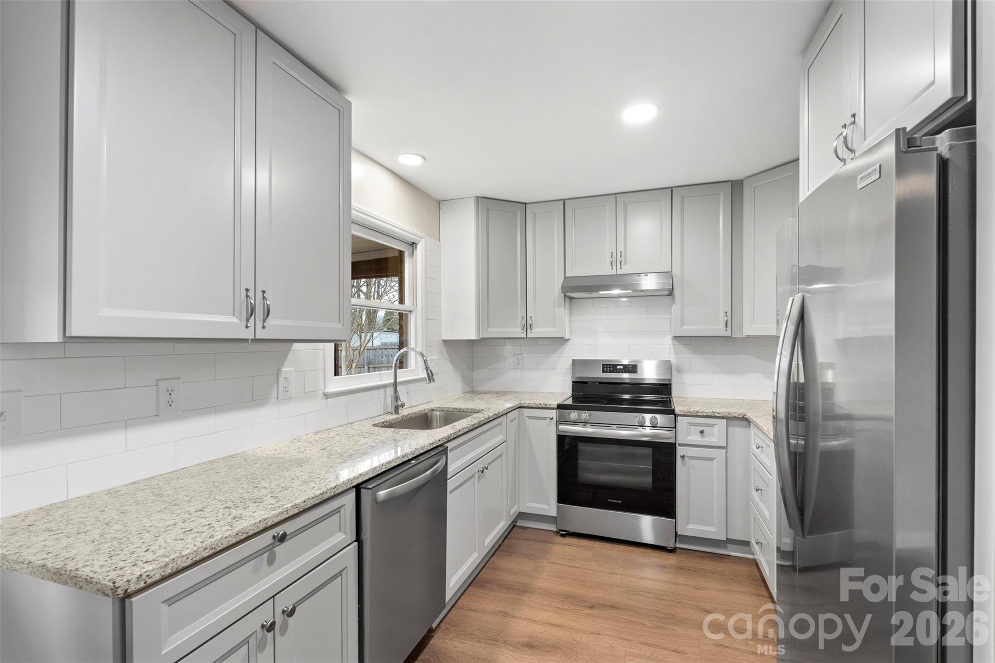 225 Belhaven Circle Clover, SC 29710 - Photo 13 of 29 a kitchen with stainless steel appliances granite countertop a stove a refrigerator and a sink