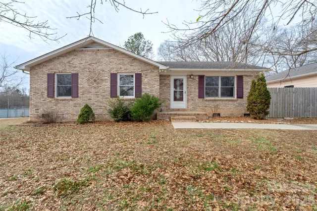 a front view of house with yard and trees around