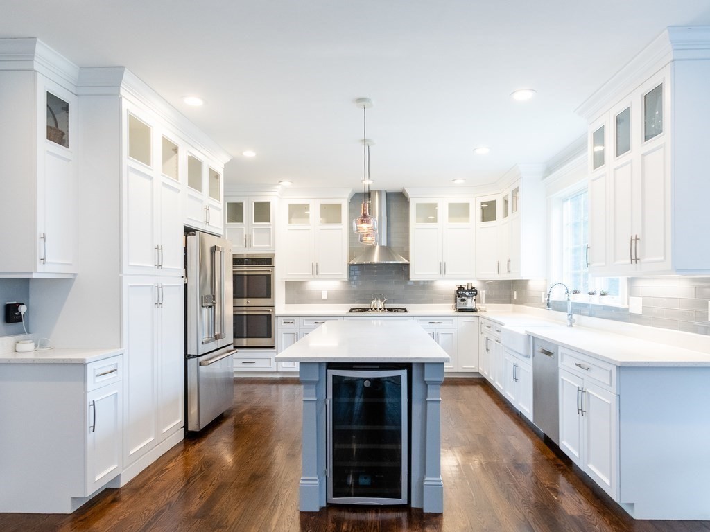 1708 Great Plain Avenue Needham, MA 02492 - Photo 7 of 34 a kitchen with stainless steel appliances granite countertop a stove top oven a sink dishwasher and a refrigerator with wooden floor