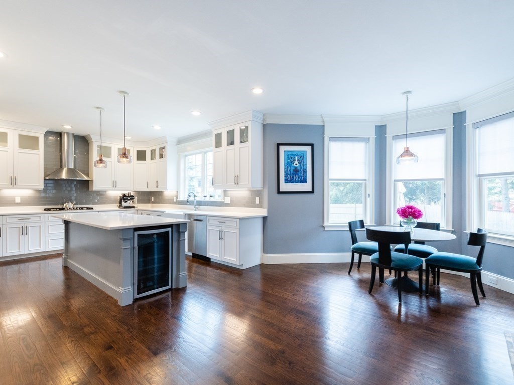 1708 Great Plain Avenue Needham, MA 02492 - Photo 9 of 34 a kitchen with stainless steel appliances granite countertop a stove top oven a sink dishwasher a dining table and chairs with wooden floor