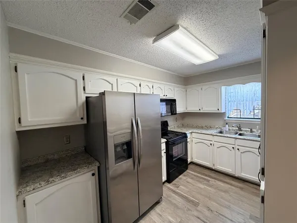 a kitchen with stainless steel appliances a refrigerator sink and cabinets