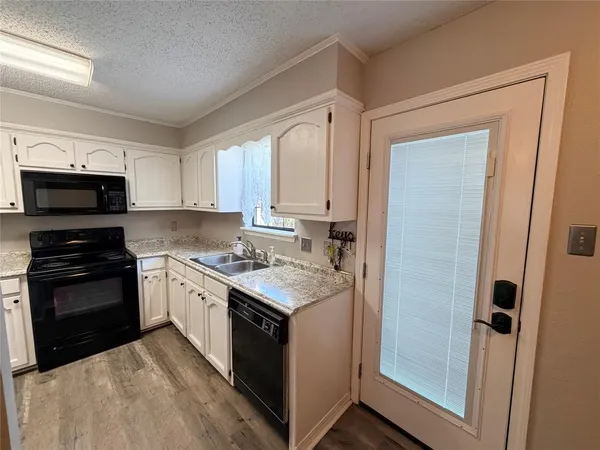 a kitchen with stainless steel appliances granite countertop a stove top oven a sink and a refrigerator