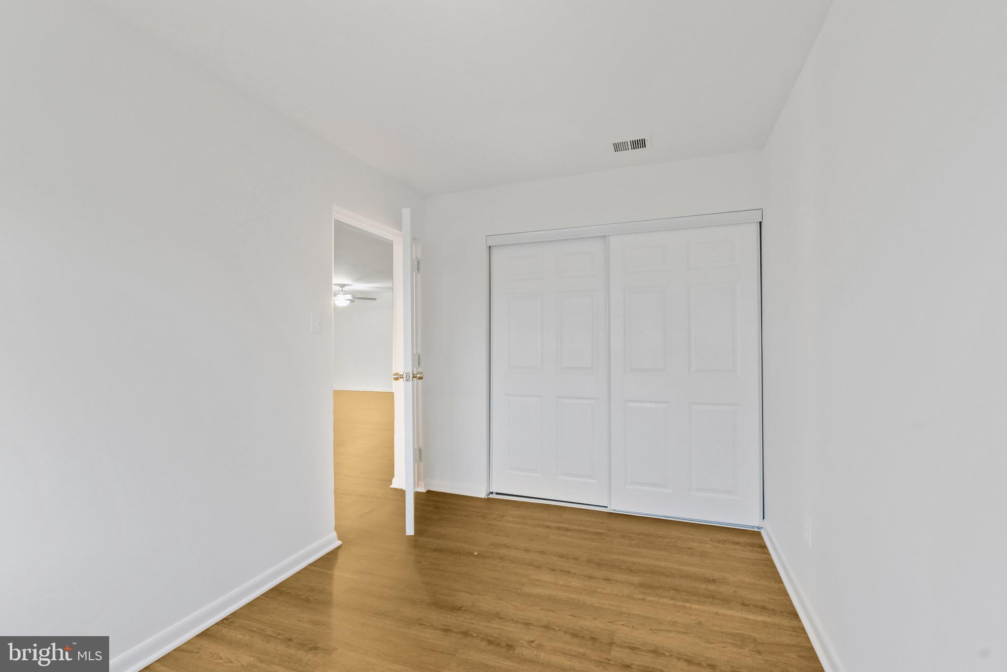 11212 Chestnut Grove Square, Unit 313 Reston, VA 20190 - Photo 13 of 22 a view of an empty room with wooden floor and closet