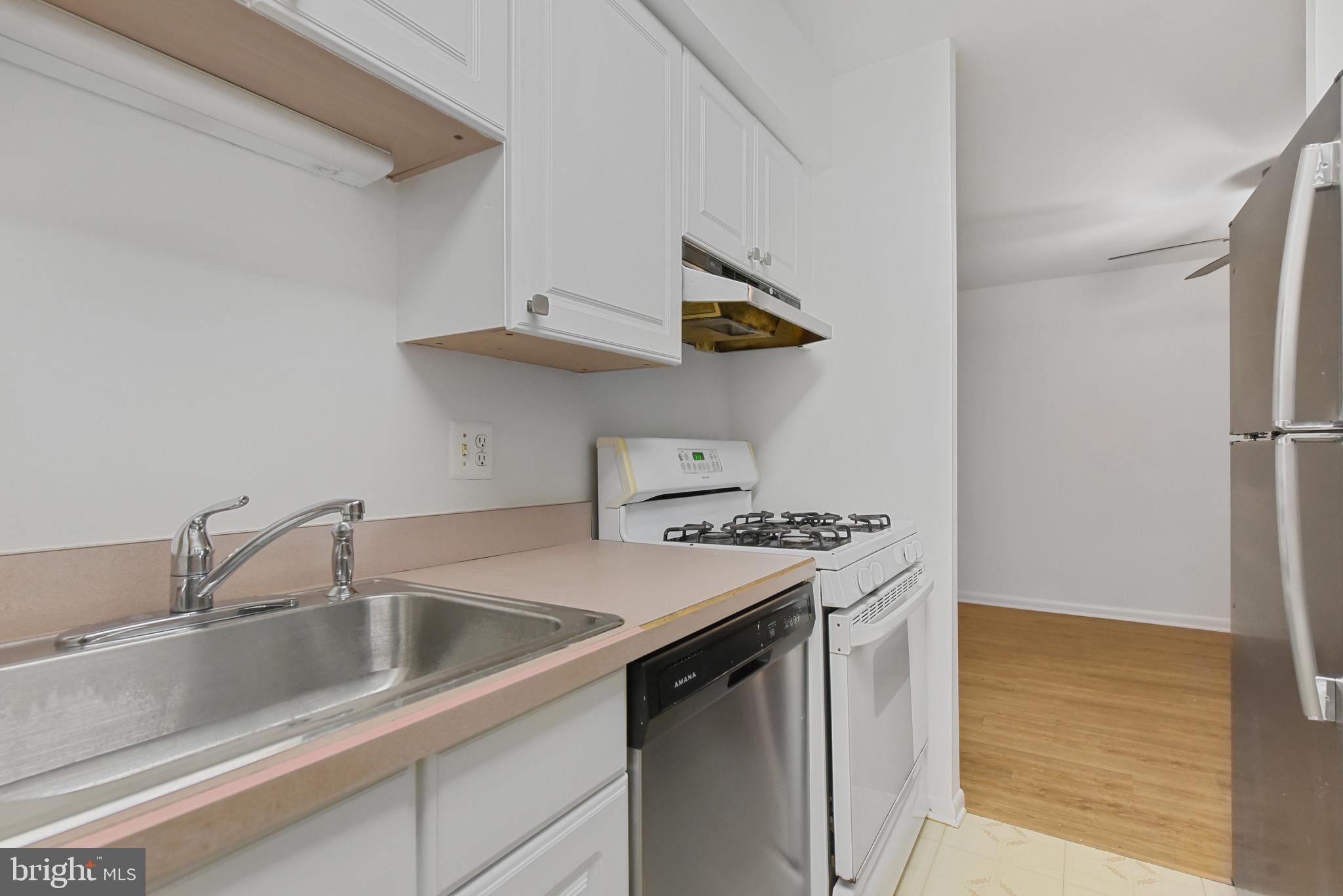 11212 Chestnut Grove Square, Unit 313 Reston, VA 20190 - Photo 9 of 22 a kitchen with stainless steel appliances a sink and a refrigerator