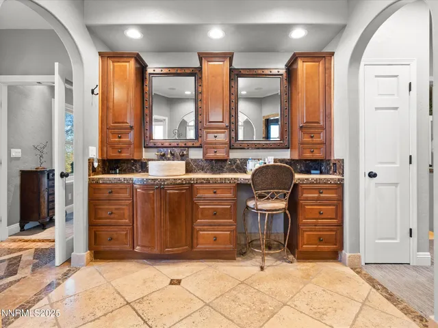 a bedroom with a large bed chandelier and a window