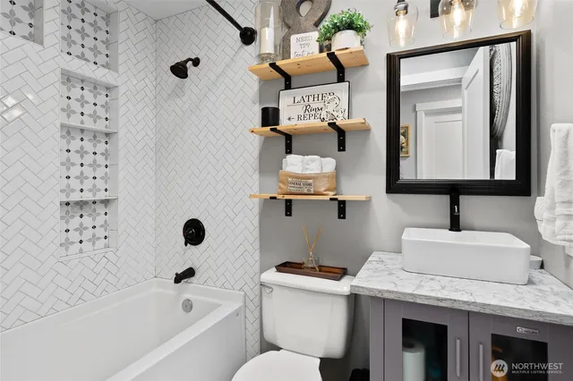 a bathroom with a granite countertop sink mirror toilet and bathtub