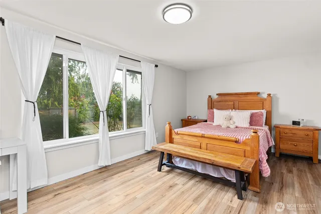 a bedroom with a bed and a large window