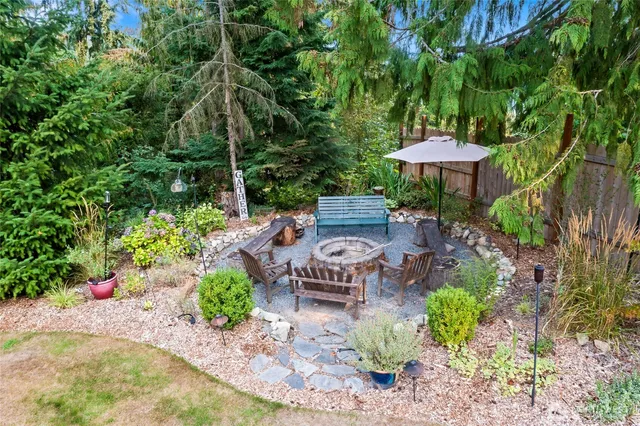 a view of a table and chairs under an umbrella in the garden