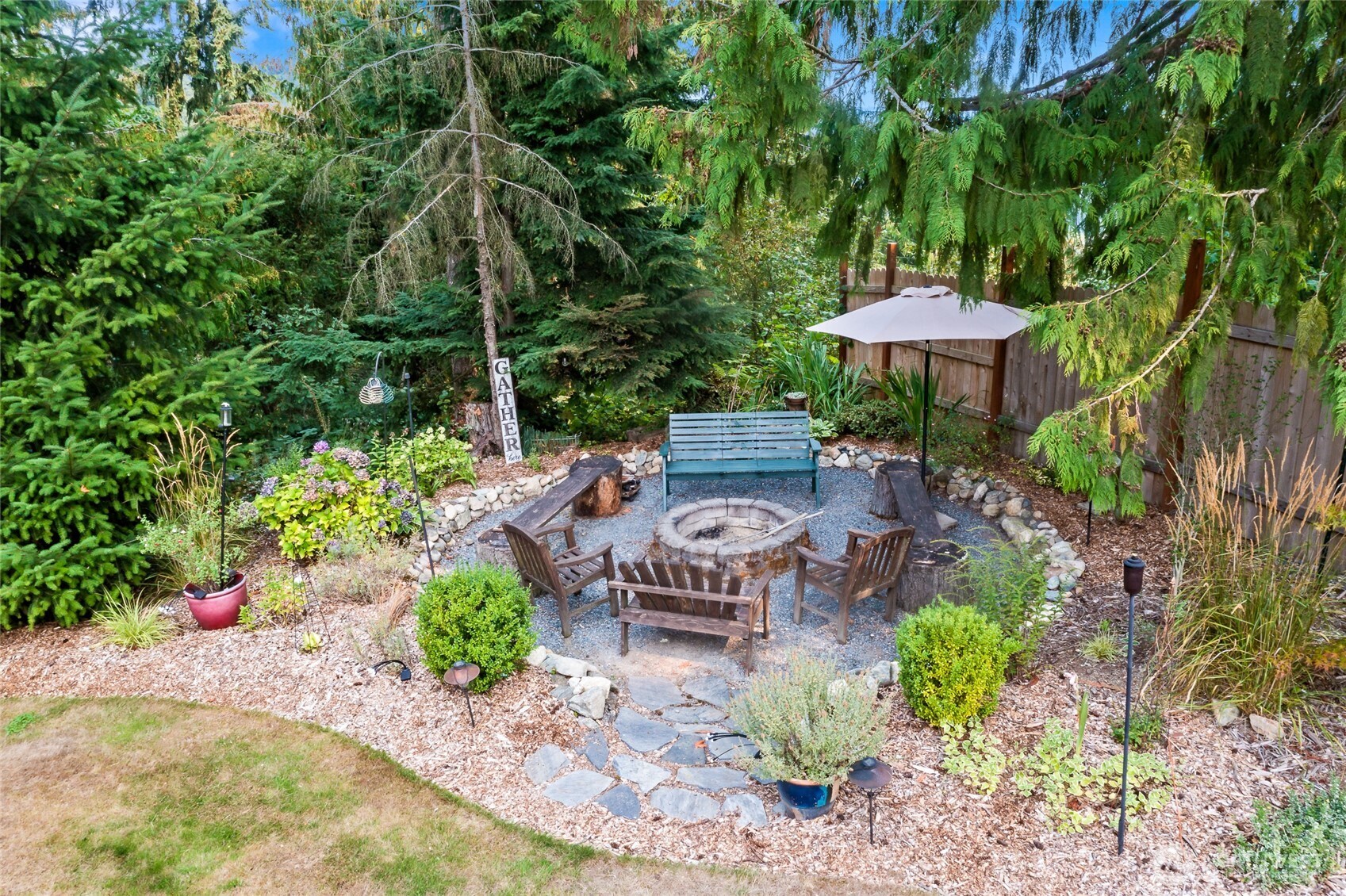 16115 243rd Street East Graham, WA 98338 - Photo 25 of 38 a view of a table and chairs under an umbrella in the garden