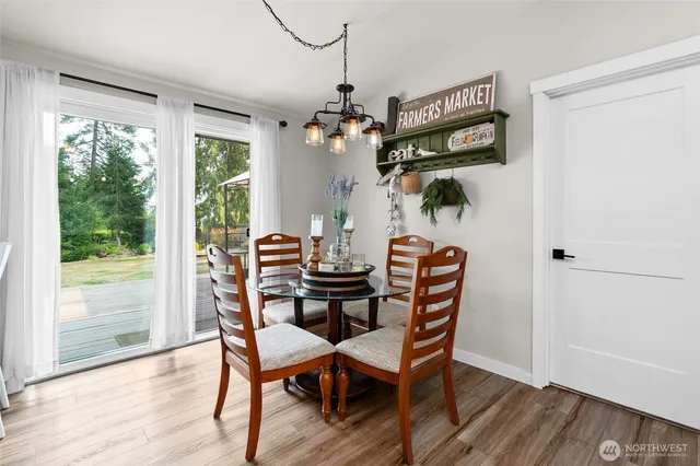 a dining room with furniture a chandelier and wooden floor