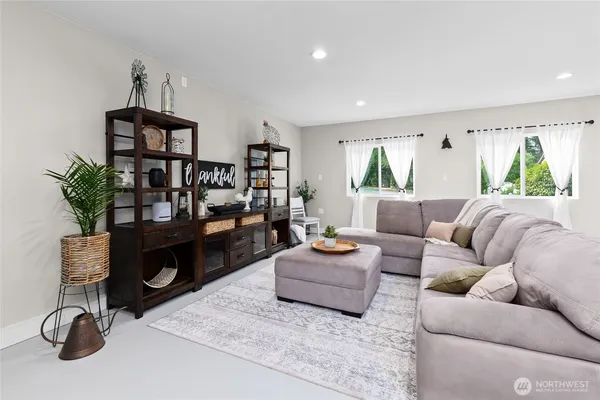 a living room with furniture flat screen tv and window