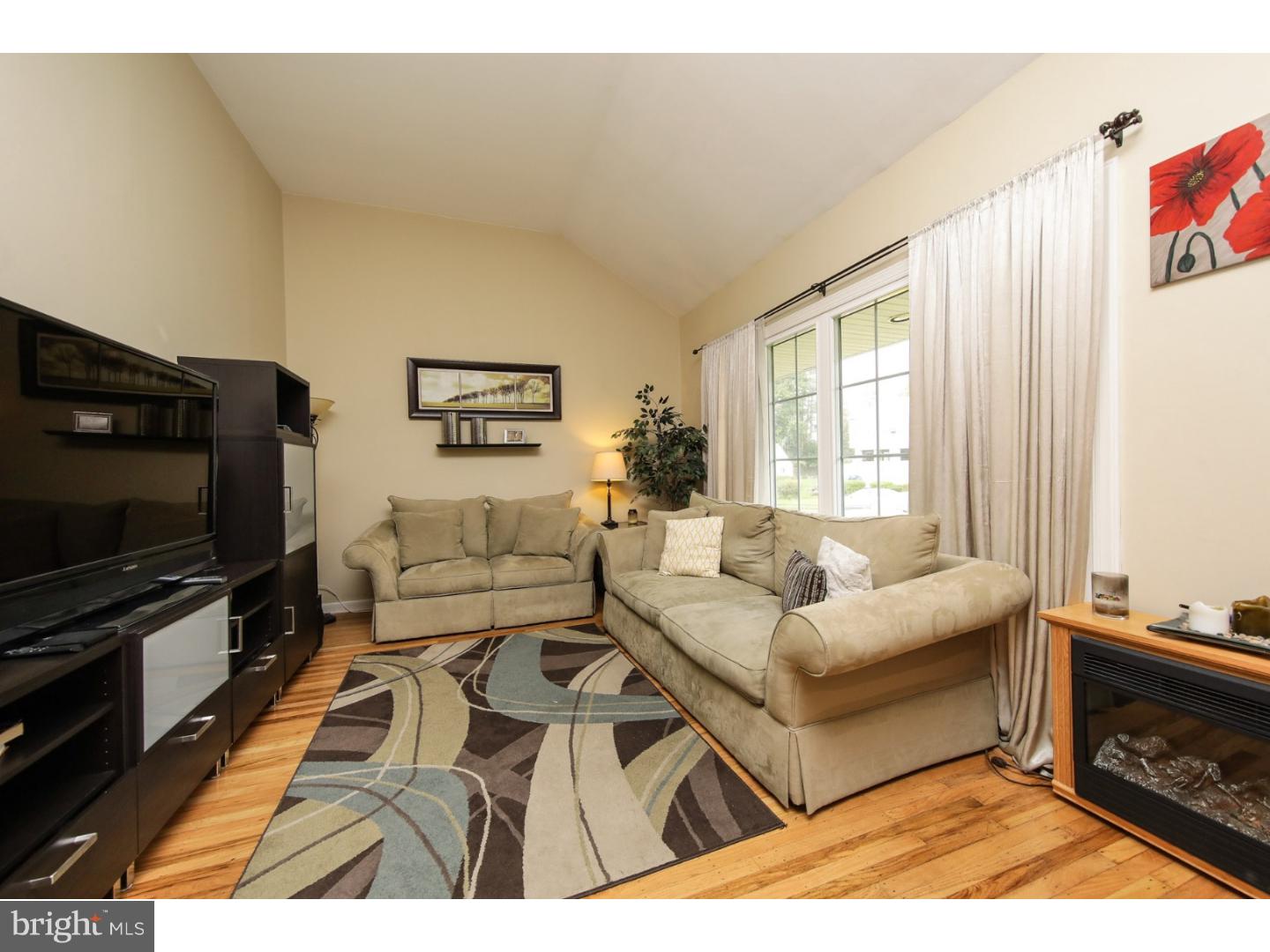 754 Spruce Road Warminster, PA 18974 - Photo 5 of 25 a living room with furniture a flat screen tv and a fireplace