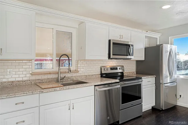 a kitchen with stainless steel appliances granite countertop a stove microwave and refrigerator