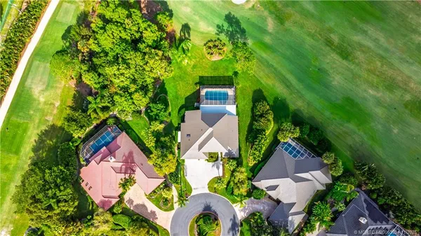 an aerial view of residential house with outdoor space and trees all around