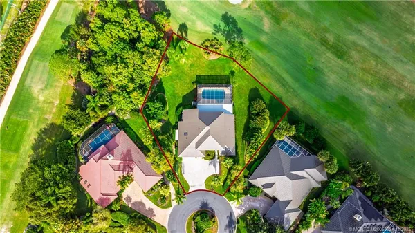 an aerial view of residential house with outdoor space and trees all around