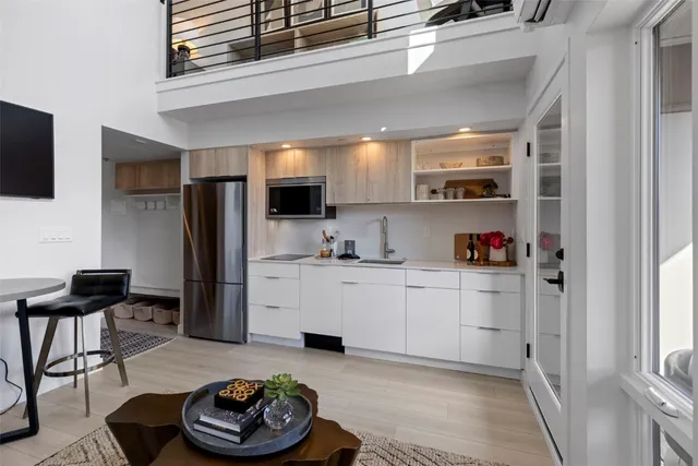 a kitchen with a refrigerator and a stove top oven