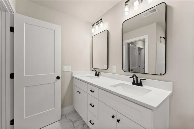 a bathroom with double sink and two mirror
