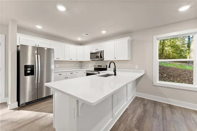 a kitchen with a refrigerator a stove top oven and a window