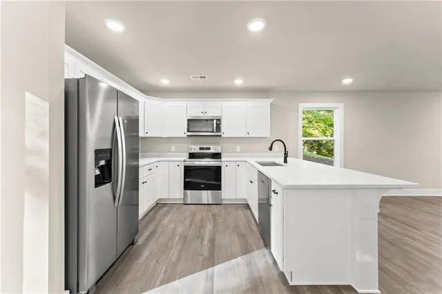 a kitchen with a refrigerator a sink and cabinets