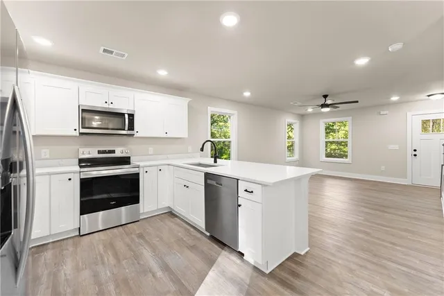a kitchen with granite countertop a stove a sink and a refrigerator