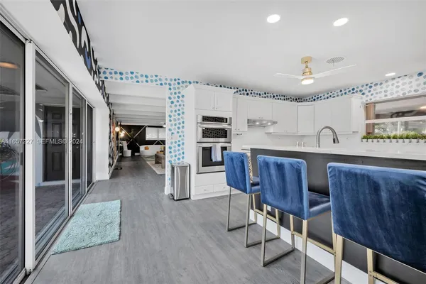 a open kitchen with cabinets a counter and chairs