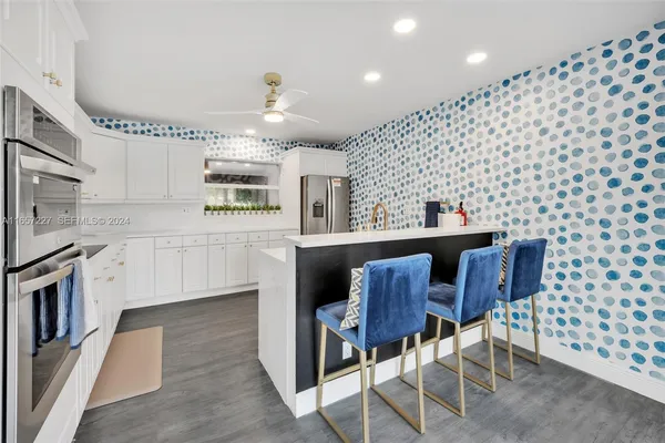 a kitchen with a sink dining table and chairs