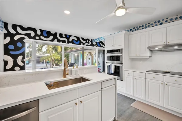 a kitchen with stainless steel appliances granite countertop a sink and a stove