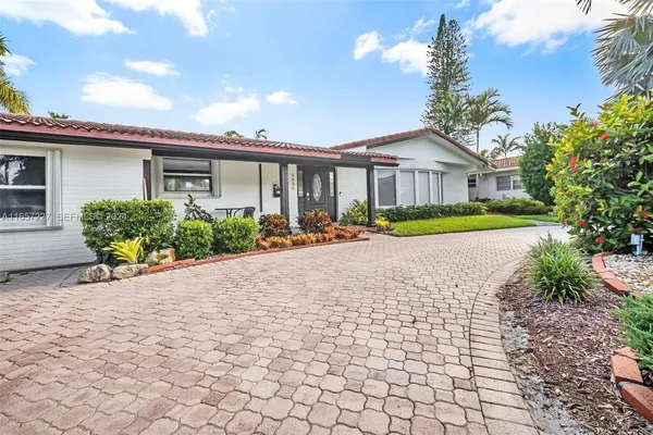 a front view of a house with a yard and potted plants