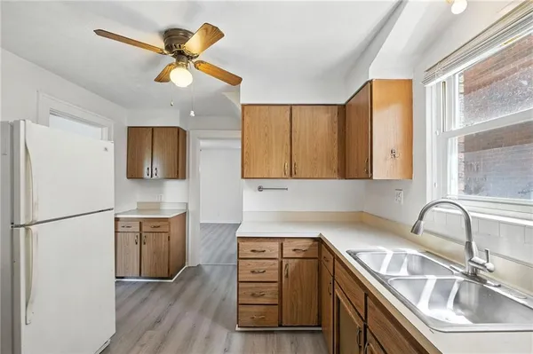 a kitchen with a sink appliances cabinets and a window