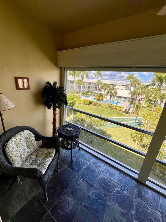 1951 Northeast 39th Street, Unit 361 Lighthouse Point, FL 33064 - Photo 17 of 27 a living room with a table and a floor to ceiling window