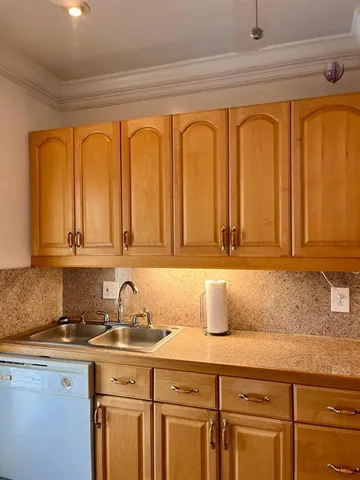 a large kitchen with stainless steel appliances a sink and a microwave