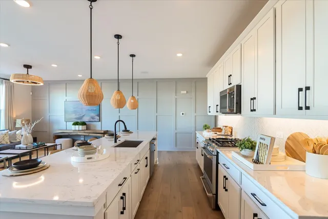 a kitchen with kitchen island granite countertop a sink a counter top space appliances and cabinets