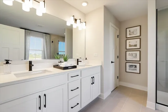 a bathroom with a double vanity sink a mirror a bathtub and