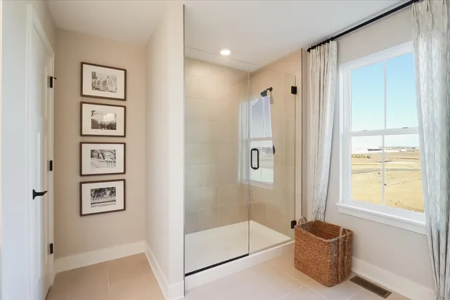 a bathroom with a tub shower and mirror
