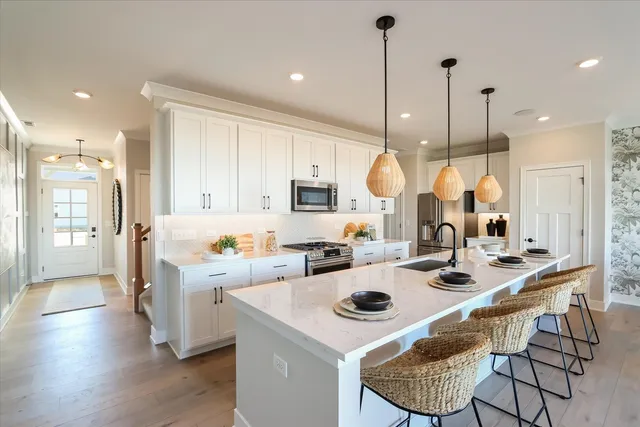 a kitchen with a sink a stove a refrigerator and chairs