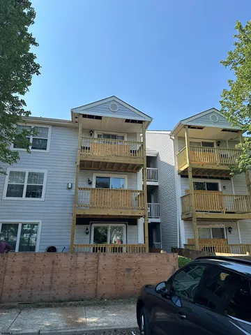 a front view of a building with glass windows and a yard
