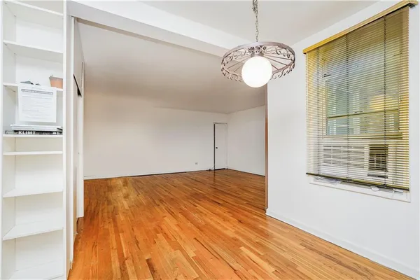 a view of a room with wooden floor and a window