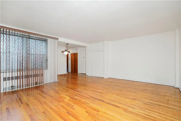 a view of an empty room with wooden floor