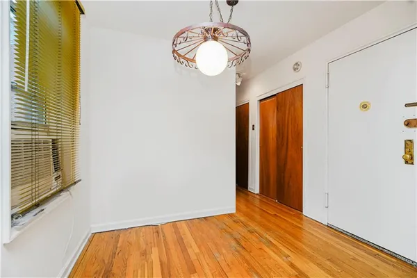 a view of empty room with window and chandelier