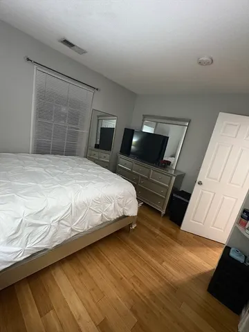 a bedroom with a bed and wooden floor