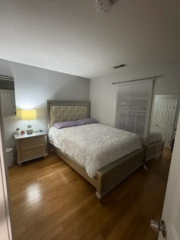 a bedroom with a bed and wooden floor