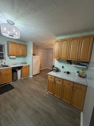 a kitchen with stainless steel appliances granite countertop a sink a stove counter space and cabinets