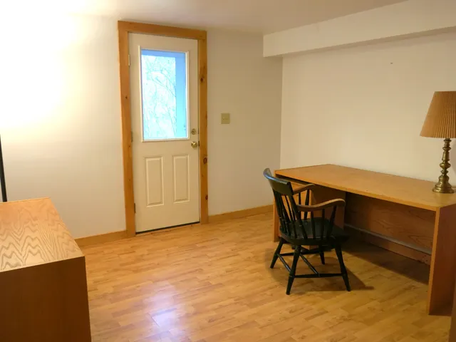 a workspace room with wooden floor and furniture