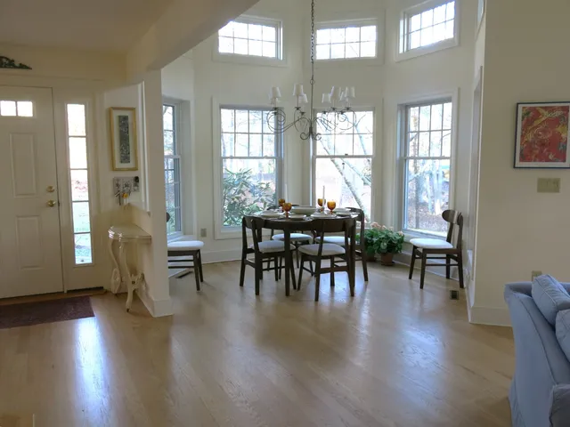 a view of a a dining room with furniture window and wooden floor