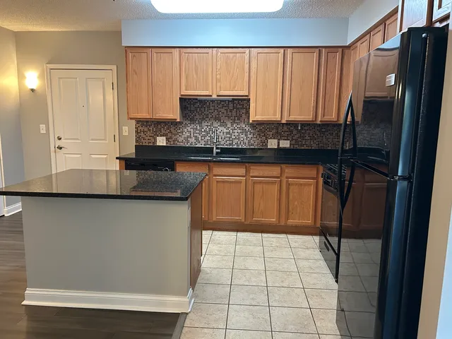 a kitchen with stainless steel appliances granite countertop a refrigerator sink and cabinets