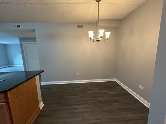 a view of a room with wooden floor and chandelier