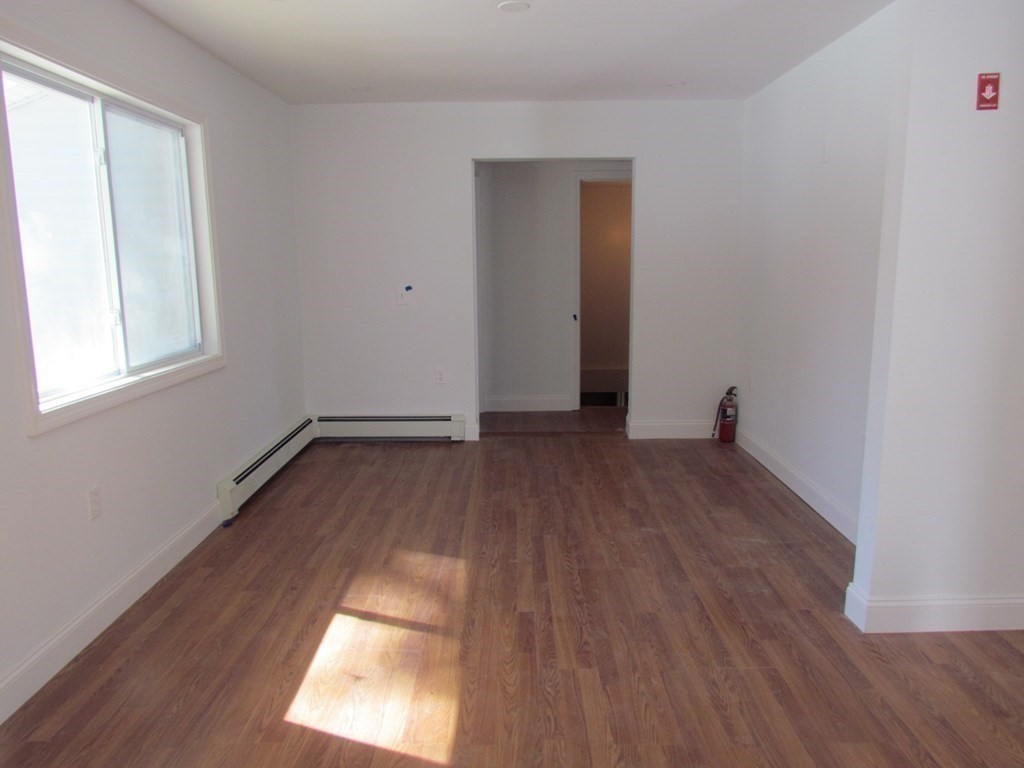 116 Williamsville Road Hubbardston, MA 01452 - Photo 21 of 27 an empty room with wooden floor and windows