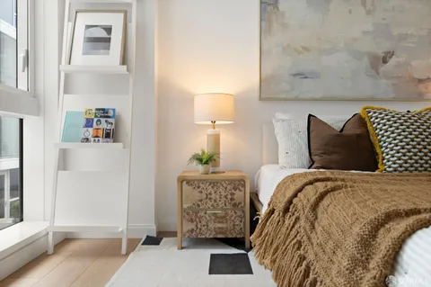 a bed sitting in a bedroom next to a window and a lamp