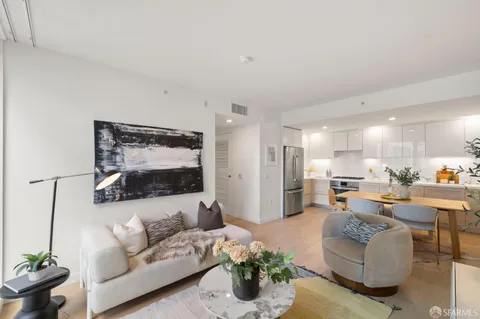 a living room with furniture and a large mirror with potted plant