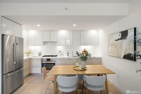 a kitchen with refrigerator and chairs